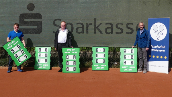 Sparkassenfilialleiter Bernd Ottenjann (Mitte) überreichte sieben neue Spielstandanzeiger an den TCO-Vorstand rund um Lukas Peschke (links) und den 1. Vorsitzenden Peter Börsch (rechts). Foto: Tennisclub Ostbevern.